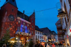 Eine geschmückte Straße auf dem Weihnachtsmarkt in Haguenau, die am Abend beleuchtet ist